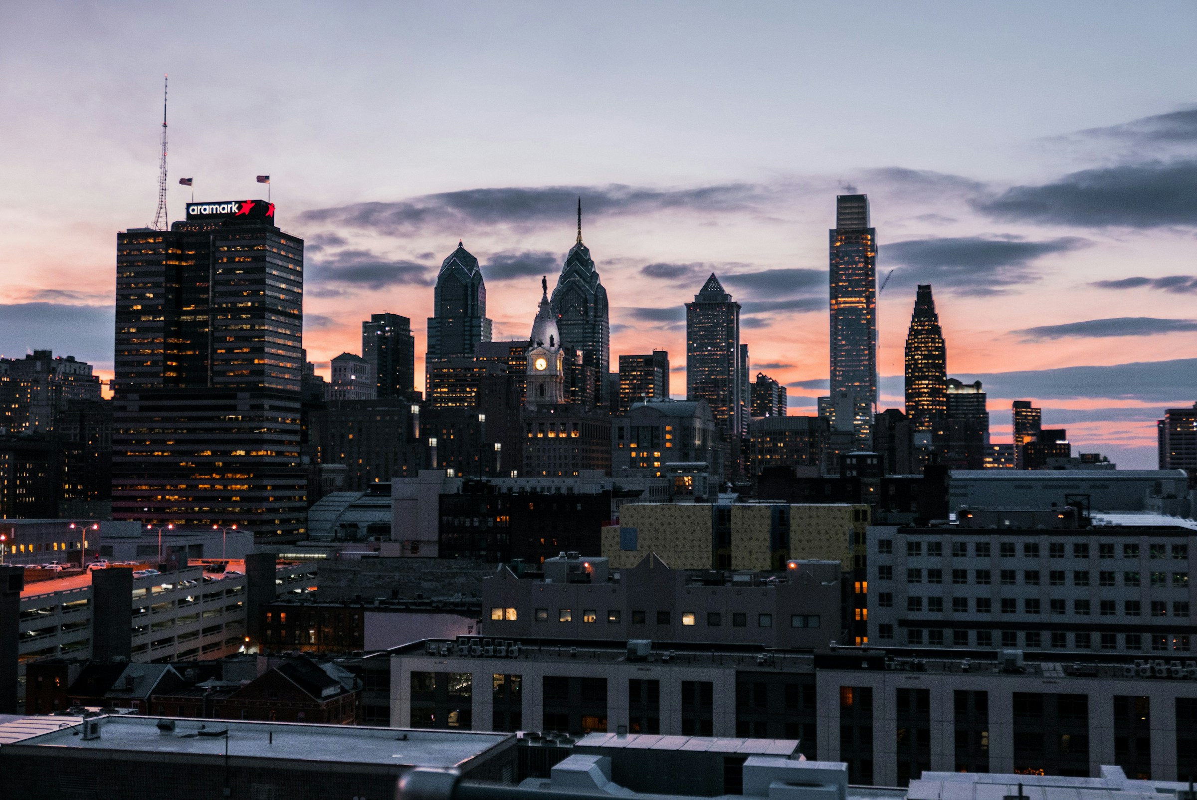 The Philadelphia skyline at dusk, lights reflecting on the river